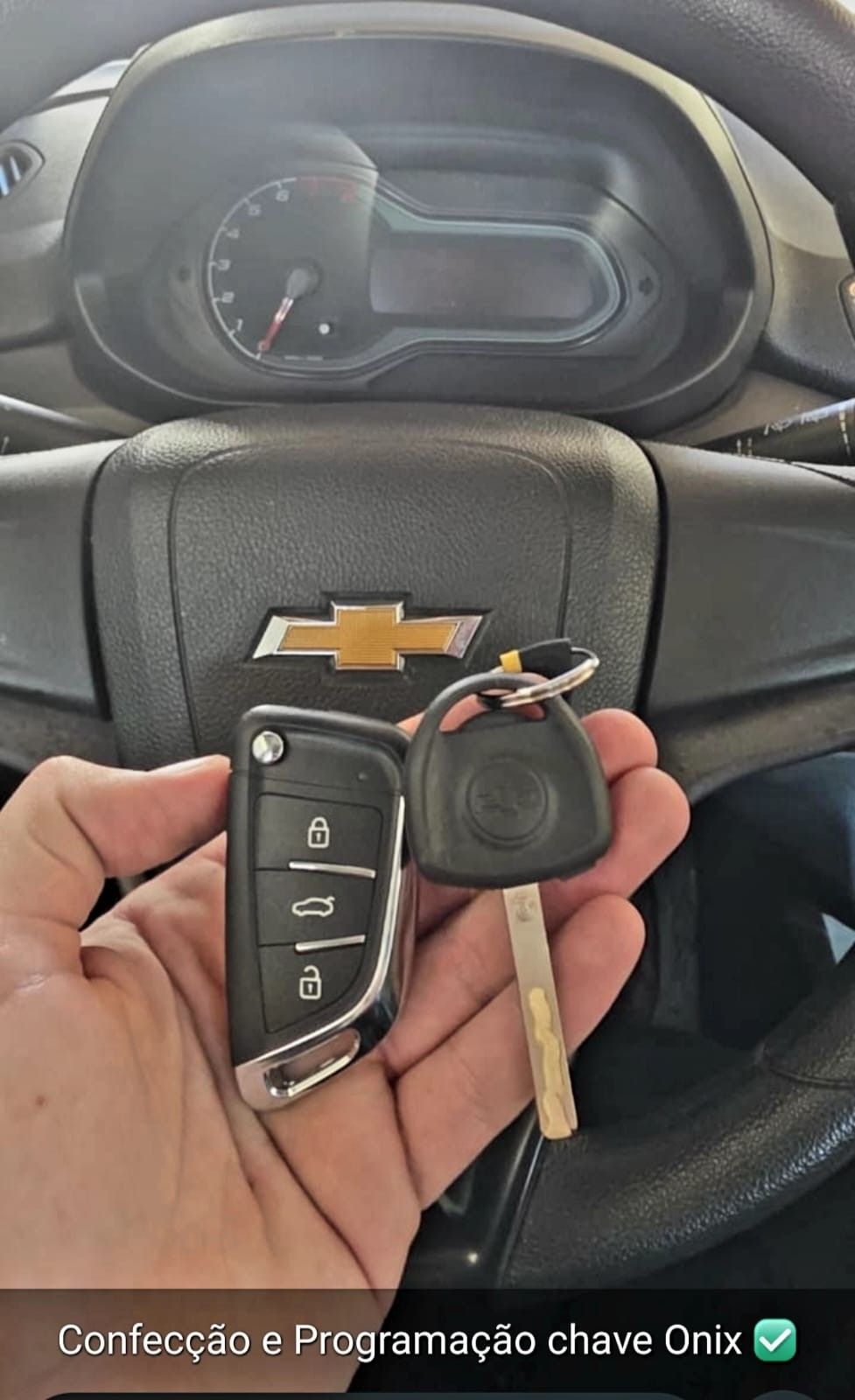 Chave canivete e chave original de um Chevrolet Onix em frente ao volante