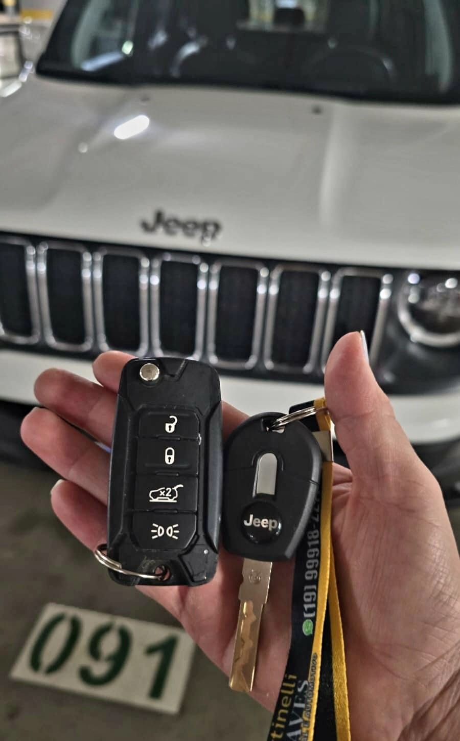 Chave canivete e chave Jeep em frente à grade do veículo