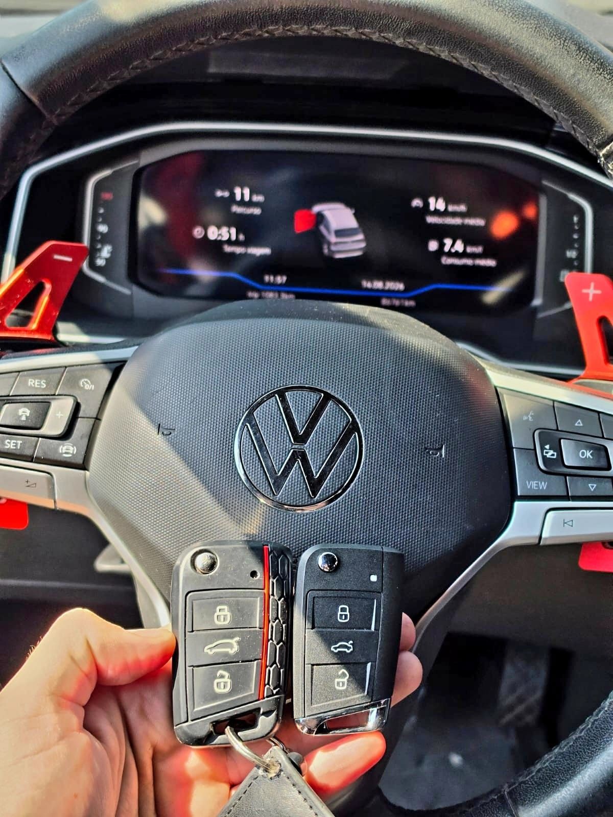 Duas chaves canivete Volkswagen em frente ao painel digital do veículo