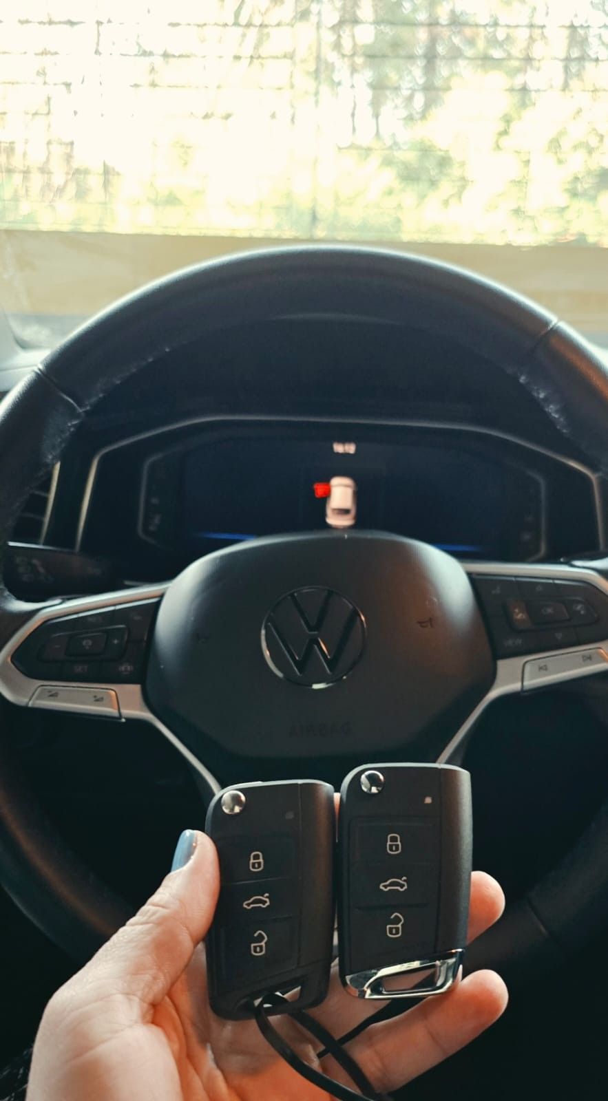 Duas chaves canivete em frente ao volante Volkswagen