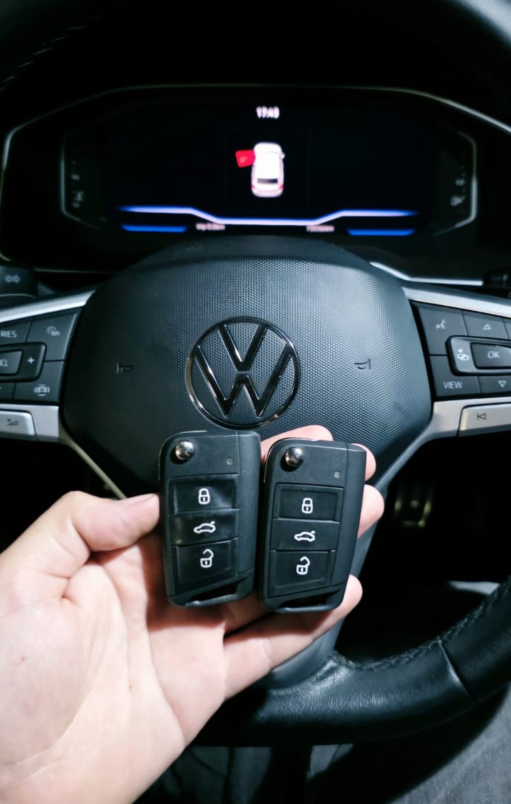 Duas chaves canivete em frente ao volante e painel digital Volkswagen