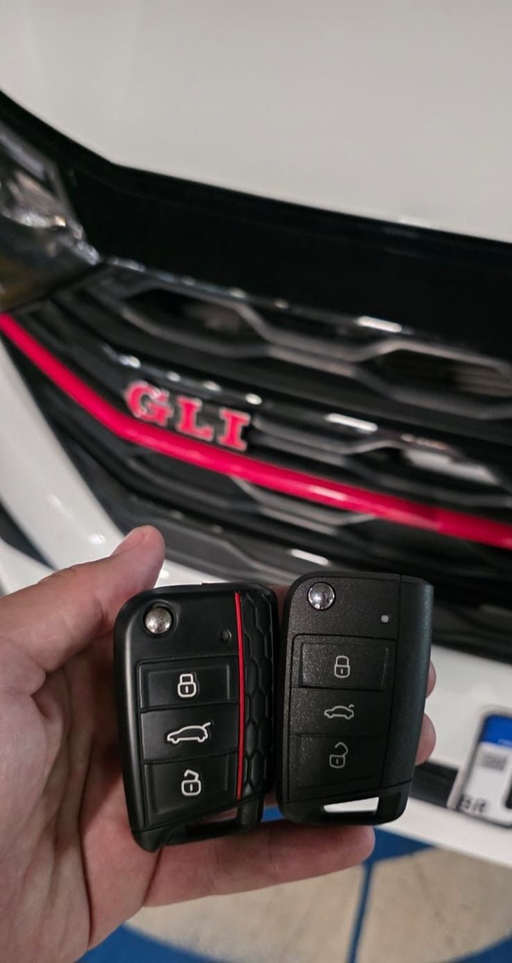 Duas chaves canivete Volkswagen em frente à grade de um Jetta GLI