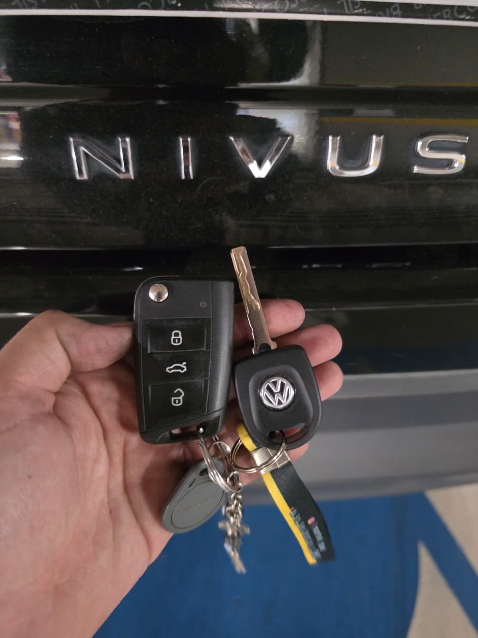 Chave canivete e chave Volkswagen em frente ao letreiro Nivus