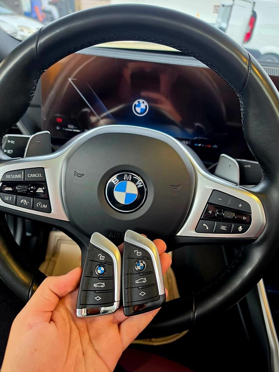 Duas chaves presenciais BMW em frente ao volante do veículo