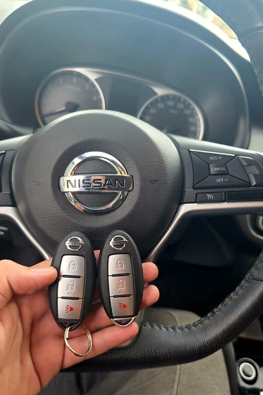 Duas chaves presenciais Nissan em frente ao volante