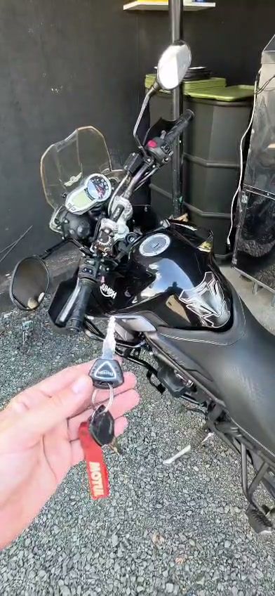 Quadro do vídeo: chave de motocicleta Triumph em frente à moto
