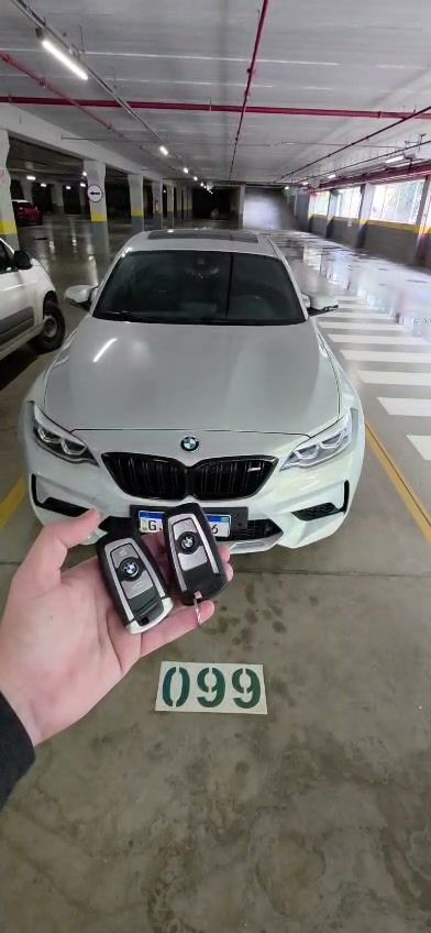 Quadro do vídeo: duas chaves presenciais BMW em frente ao carro